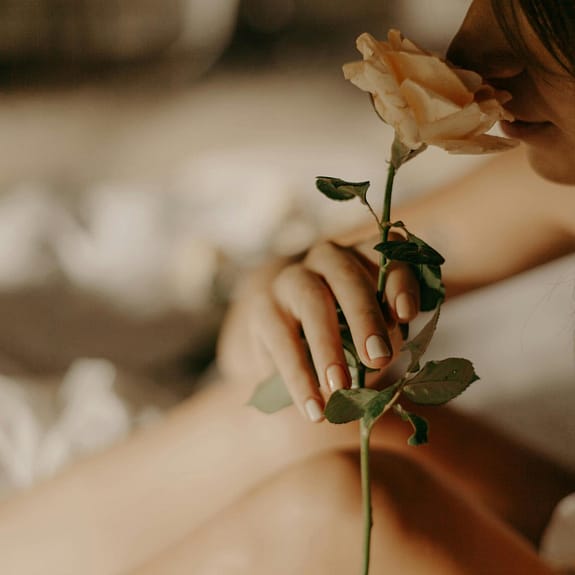 woman smelling rose best floral perfume for women