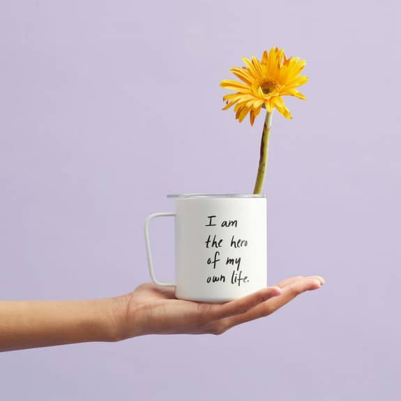 woman holding cup with flower self care affirmations
